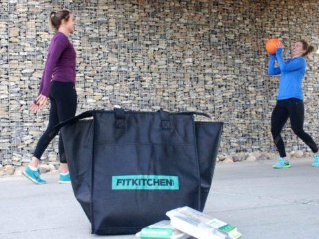 2 youg girls playing with a ball in the background of Fitkitchen delivery bag