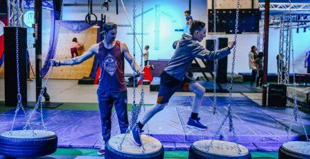 Teenager running across Ninja style obstacle course