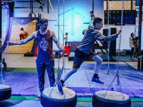 Teenager running across Ninja style obstacle course