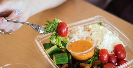 Salad with dressing in the middle. Cherry tomatoes, cucumber chunks, feta cheese