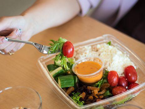 Salad with dressing in the middle. Cherry tomatoes, cucumber chunks, feta cheese